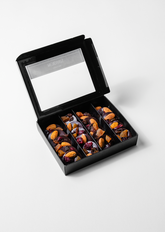 Dark chocolate medallion topped with crunchy nuts and dried fruits.