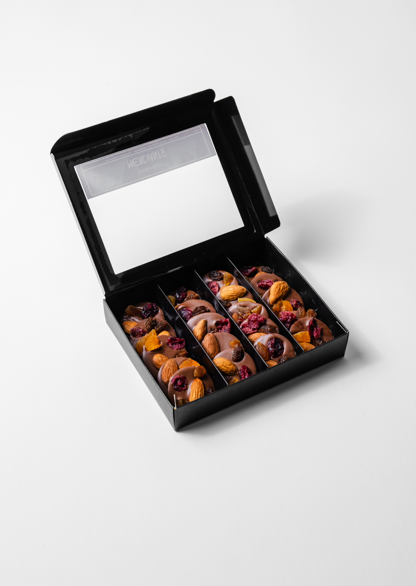 milk chocolate medallion topped with crunchy nuts and dried fruits.